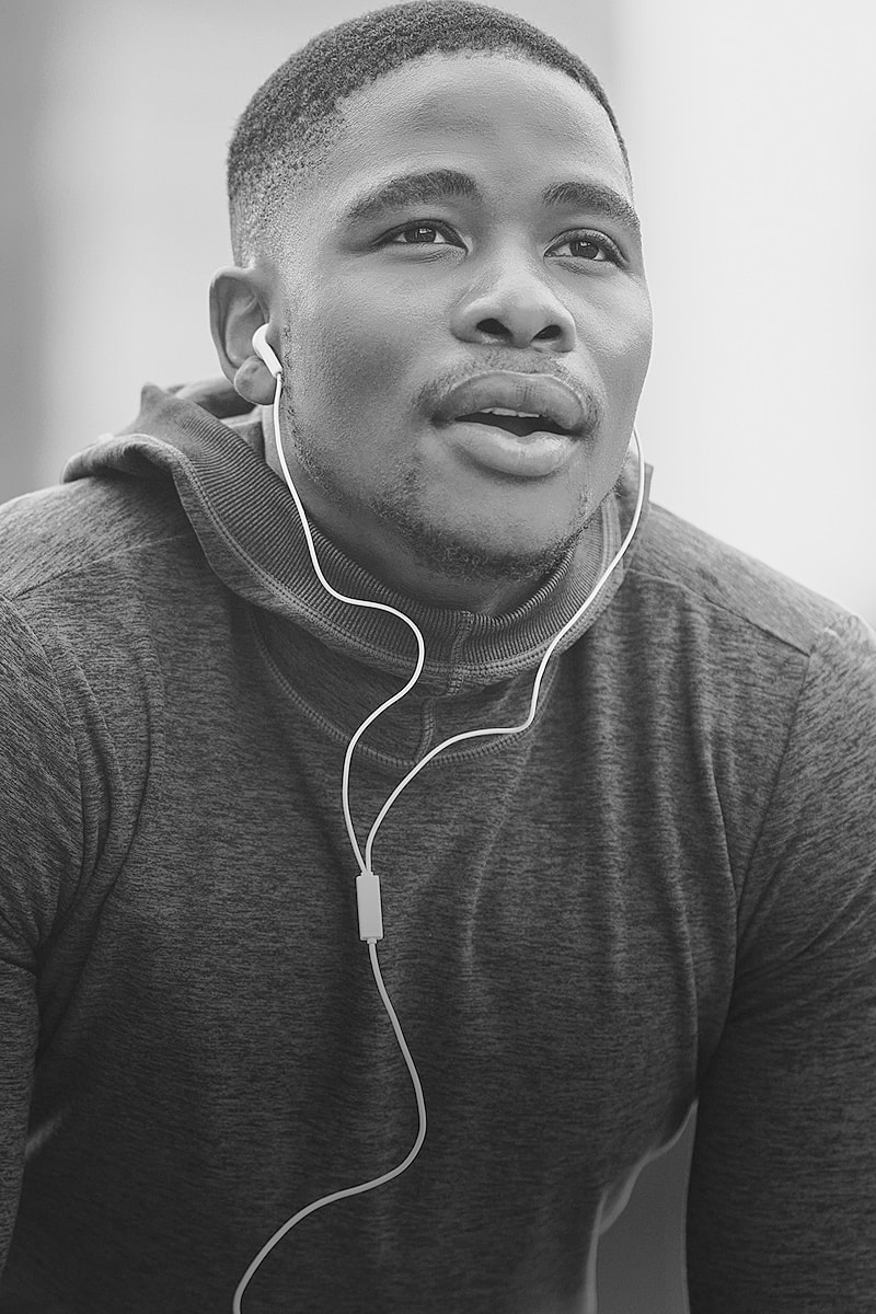 Man wearing headphones, looking thoughtfully upwards.