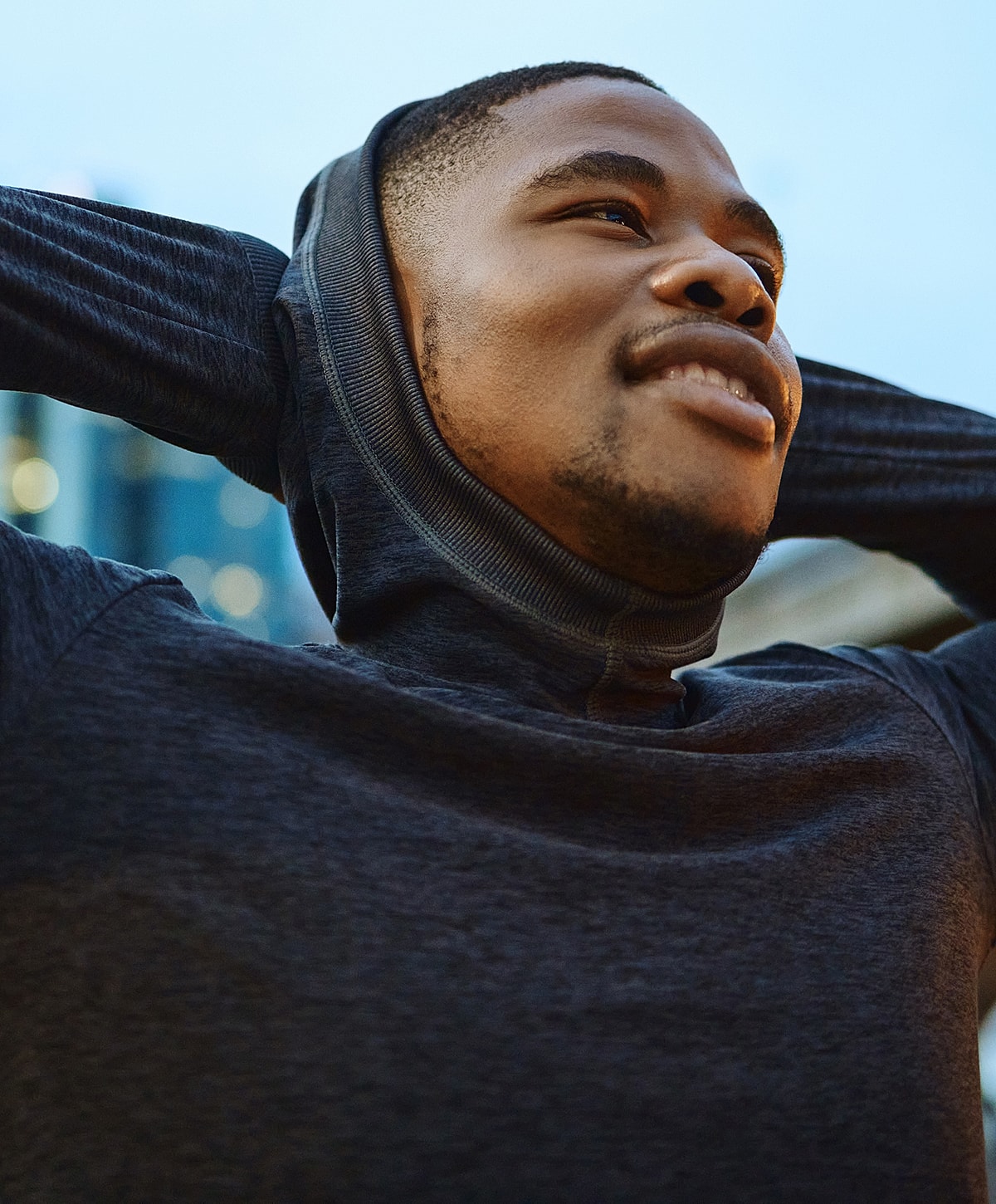 Man in hoodie enjoying the moment outdoors.