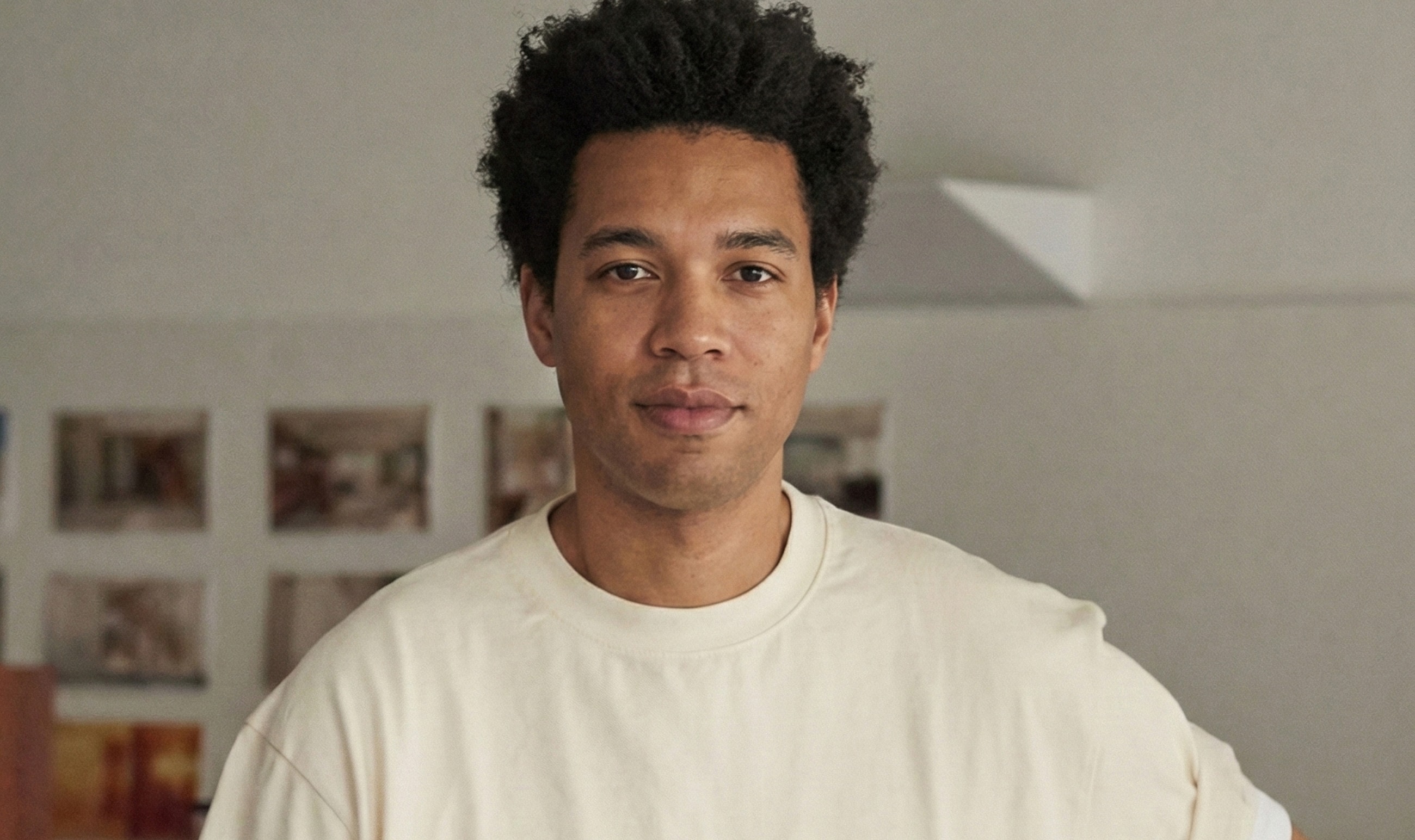 Man with curly hair, wearing a light shirt.